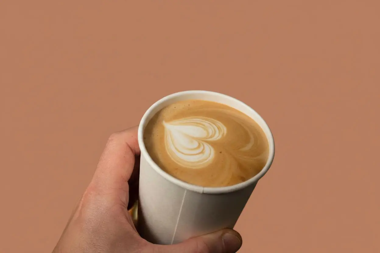 Takeaway Italian cappuccino in a to-go cup, freshly prepared coffee to enjoy on the move